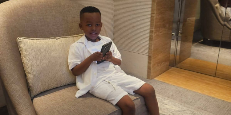 Sonko Shares How Baby James Refused To Go Back To Kisii, Calls Out Clout Chasers Baby James Using A Smartphone. Photo/Mike Sonko(X)