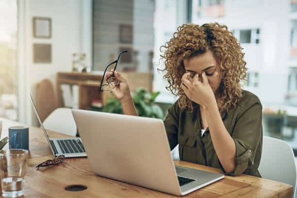 Shot Of A Young Woman Suffering From Stress While Using A Computer At Her Work Desk