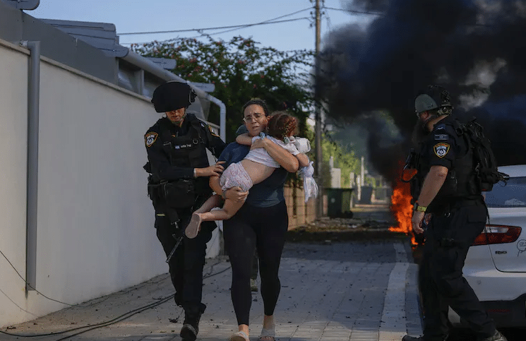 Israeli Police Officers Evacuate A Woman And Child From A Site Hit By A Rocket In Ashkelon, Southern Israel. 