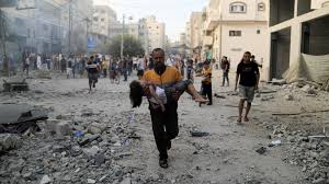 A Palestinian Carries A Child After An Israeli Air Strike In Khan Yunis In The Southern Gaza Strip On 14 October 2023 | Afp