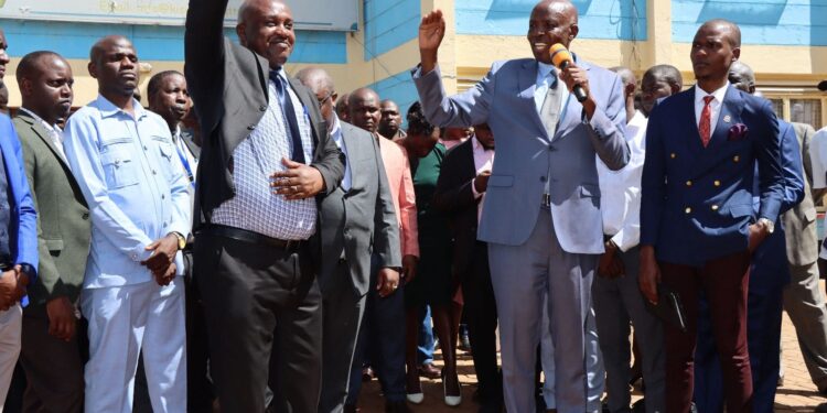 Education Cabinet Secretary Ezekiel Machogu (Holding A Microphone) Speaks During His Visit To Kisiii University Alongside Housing Ps Charles Hinga. 