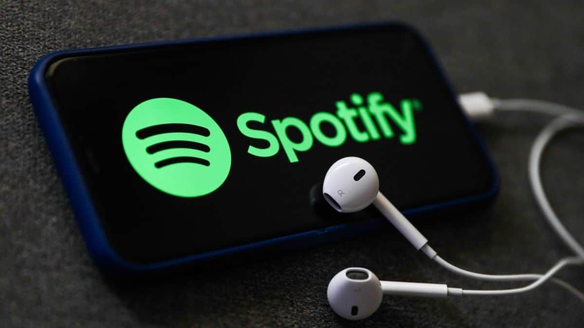 Spotify. A Spotify Logo On Phone And Earphones.