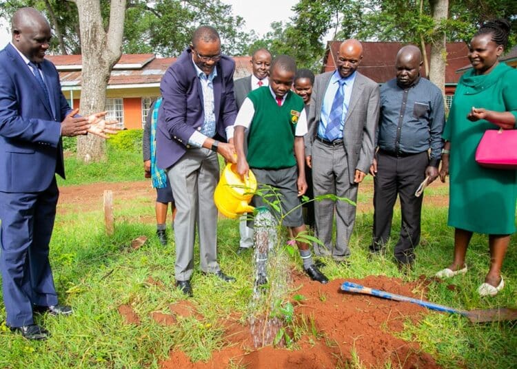 Cs Owalo Pays Full School Fees For Needy Kcpe Candidate Ict Cs Eliud Owalo And David Odhiambo Watering A Tree At Maseno School.