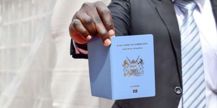 An Image Of A Man Holding The Kenyan Passport.