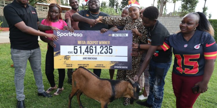 Jane Mwendwa Receives Her Cheque From A Sportpesa Representative After Winning The Mega Jackpot