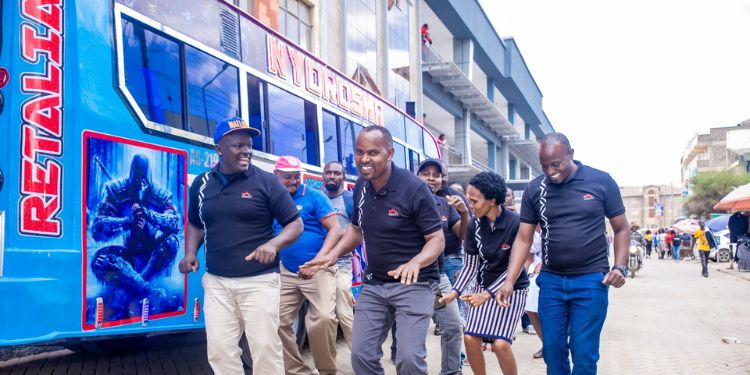 Members Of Nyoroma Self Help Group And Some Of Their Families Led By Their Chairman, Alex Muthama Break Into Song And Dance During The Handover Ceremony Of Their Bus Outside Equity Bank Kenya Rongai Branch.